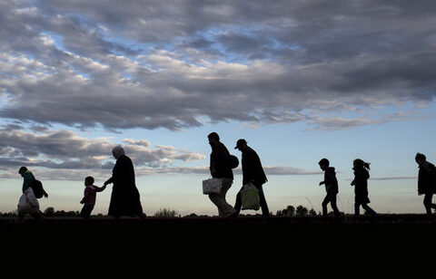 Migrants walk along