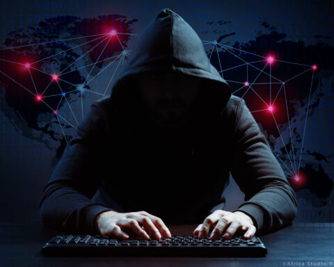 Hacker using keyboard on dark background