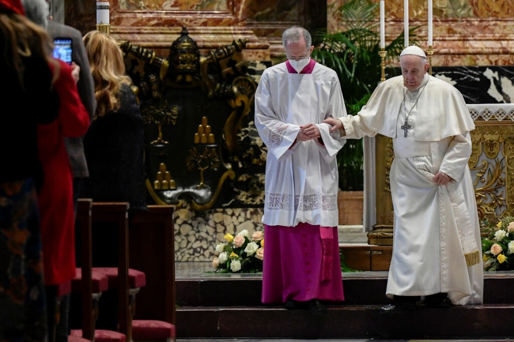 Italian priest Guido Marini helps Pope Francis