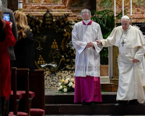 Italian priest Guido Marini helps Pope Francis
