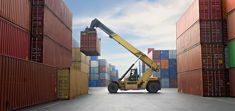 Crane lifting up container in a port.