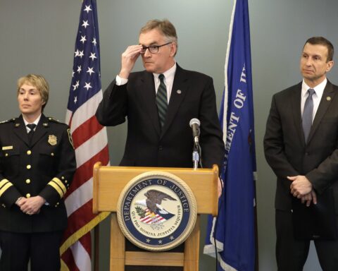 .S. Attorney Brian Moran, center, is flanked by Seattle Assistant Chief of Police Deanna Nollette
