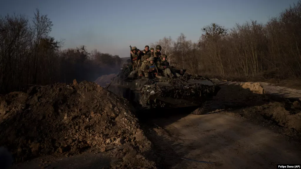 Ukrainian soldiers ride atop