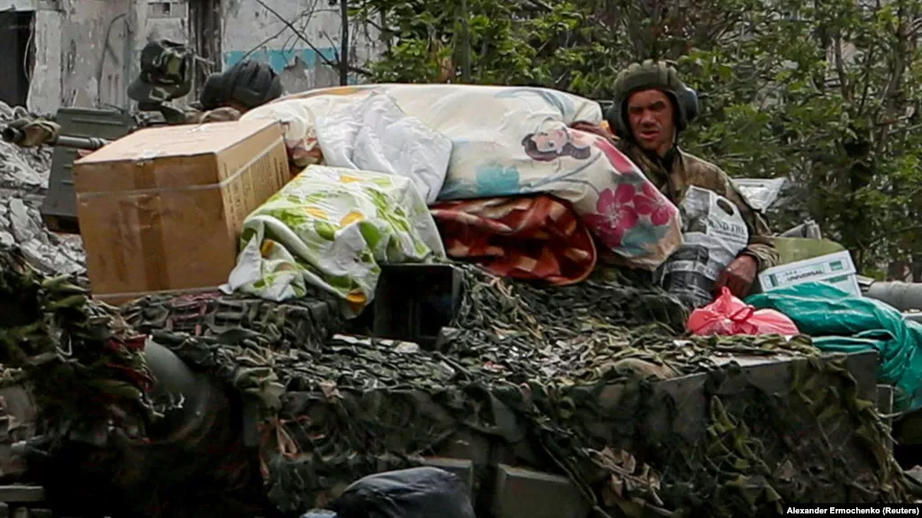 Russian soldiers atop an armored vehicle in the Ukrainian town