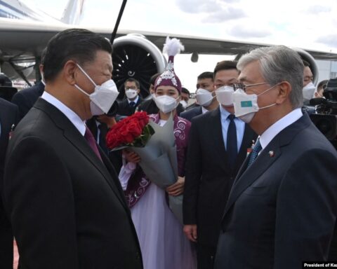 Kazakh President Qasym-Zhomart Toqaev (left) greets his Chinese counterpart, Xi Jinping